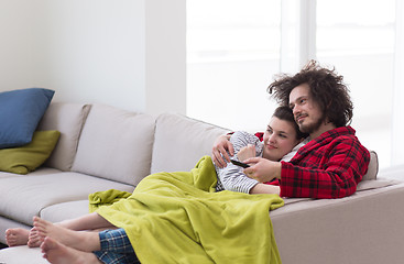 Image showing Young couple on the sofa watching television