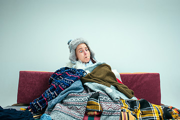 Image showing The young woman with Flue Sitting on Sofa at Home. Healthcare Concepts.