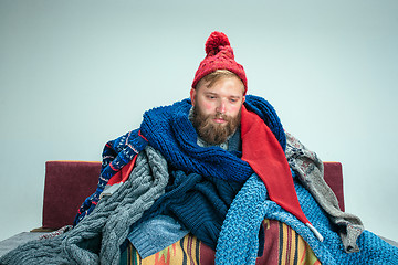 Image showing Bearded Man with Flue Sitting on Sofa at Home. Healthcare Concepts.