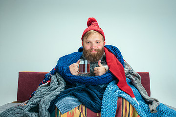 Image showing Bearded Man with Flue Sitting on Sofa at Home. Healthcare Concepts.