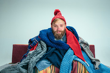 Image showing Bearded Man with Flue Sitting on Sofa at Home. Healthcare Concepts.