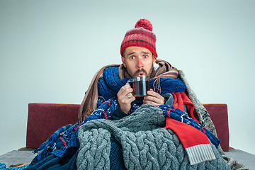 Image showing Bearded Man with Flue Sitting on Sofa at Home. Healthcare Concepts.