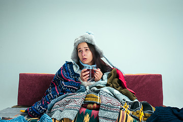 Image showing The young woman with Flue Sitting on Sofa at Home. Healthcare Concepts.