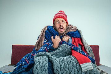 Image showing Bearded Man with Flue Sitting on Sofa at Home. Healthcare Concepts.