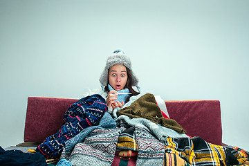 Image showing The young woman with Flue Sitting on Sofa at Home. Healthcare Concepts.