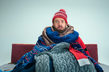 Image showing Bearded Man with Flue Sitting on Sofa at Home. Healthcare Concepts.