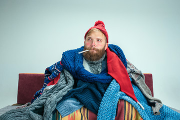 Image showing Bearded Man with Flue Sitting on Sofa at Home. Healthcare Concepts.