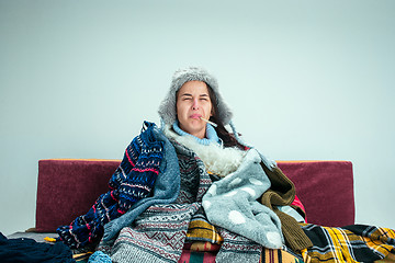 Image showing The young woman with Flue Sitting on Sofa at Home. Healthcare Concepts.