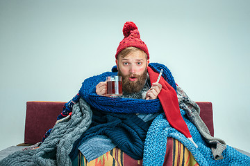 Image showing Bearded Man with Flue Sitting on Sofa at Home. Healthcare Concepts.