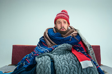 Image showing Bearded Man with Flue Sitting on Sofa at Home. Healthcare Concepts.