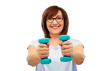 Image showing smiling senior woman with dumbbells exercising