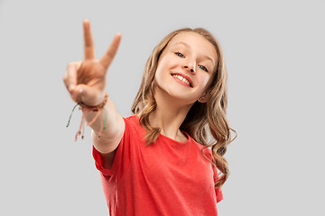 Image showing smiling teenage girl in red t-shirt showing peace