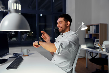 Image showing businessman using smart watch at nigh office