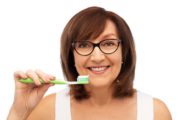 Image showing senior woman with toothbrush brushing her teeth