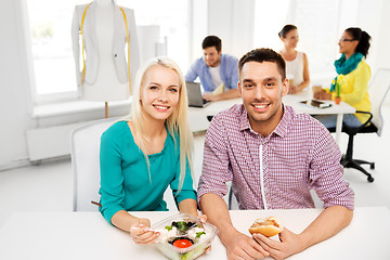 Image showing happy colleagues having lunch and eating at office