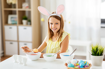 Image showing girl coloring easter eggs by liquid dye at home