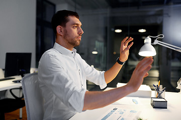 Image showing businessman using gestures at night office