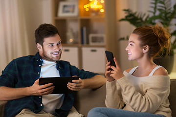 Image showing couple with tablet computer and smartphone at home