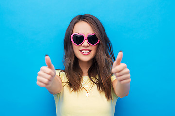 Image showing teen girl in heart-shaped shades shows thumbs up