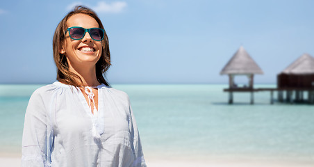 Image showing happy smiling woman in sunglasses over beach