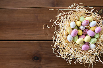 Image showing easter eggs in straw nest on wooden table