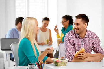 Image showing happy colleagues having lunch and eating at office