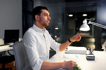 Image showing businessman using gestures at night office