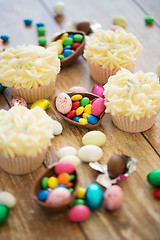 Image showing cupcakes with chocolate eggs and candies on table