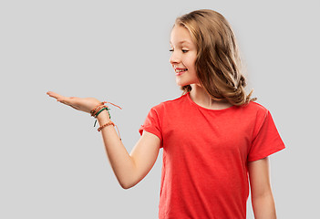 Image showing smiling teenage girl holding empty hand