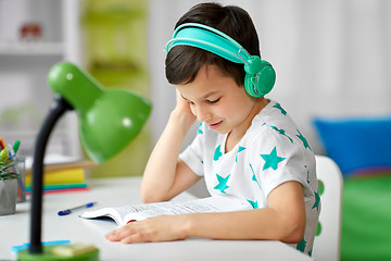 Image showing boy in headphones with textbook learning at home