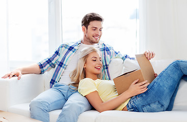 Image showing happy couple opening parcel box at home