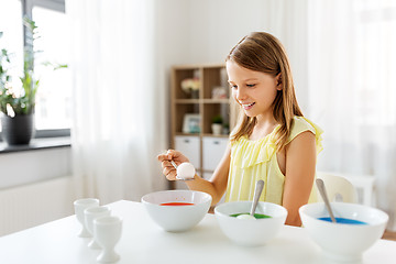 Image showing girl coloring easter eggs by liquid dye at home