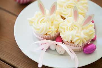 Image showing cupcakes with easter eggs and candies on table