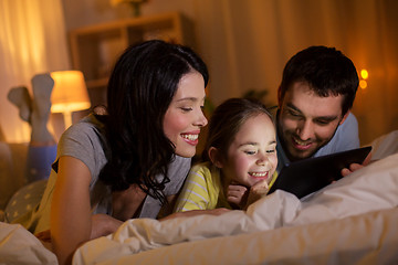 Image showing family with tablet pc in bed at night at home