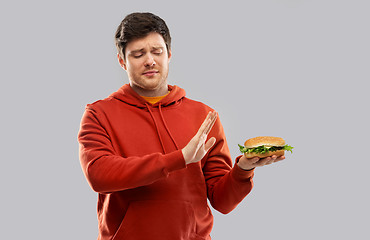 Image showing young man refusing from hamburger