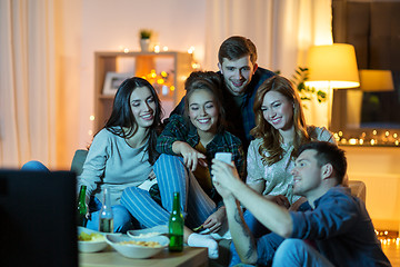 Image showing friends with smartphone watching tv at home