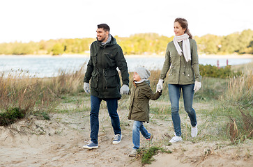 Image showing happy family walking along autumn beach