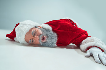 Image showing red white santa claus overworked frustration burnout concept lying on floor isolated on white background