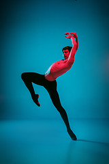 Image showing The male athletic ballet dancer performing dance on blue background. Studio shot. Ballet concept. Fit young man. Caucasian model