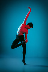 Image showing The male athletic ballet dancer performing dance on blue background. Studio shot. Ballet concept. Fit young man. Caucasian model