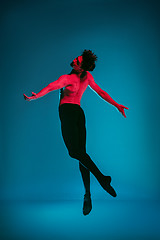 Image showing The male athletic ballet dancer performing dance on blue background. Studio shot. Ballet concept. Fit young man. Caucasian model