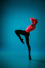 Image showing The male athletic ballet dancer performing dance on blue background. Studio shot. Ballet concept. Fit young man. Caucasian model