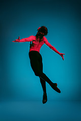 Image showing The male athletic ballet dancer performing dance on blue background. Studio shot. Ballet concept. Fit young man. Caucasian model