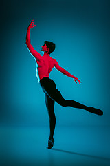 Image showing The male athletic ballet dancer performing dance on blue background. Studio shot. Ballet concept. Fit young man. Caucasian model