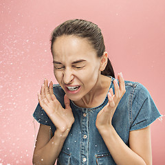 Image showing Young woman sneezing, studio portrait