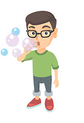 Image showing Little caucasian boy blowing soap bubbles.