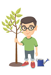 Image showing Caucasian smiling boy in glasses planting a tree.