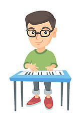 Image showing Little caucasian boy playing the piano.