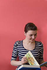 Image showing young woman sitting on floor and reading a book