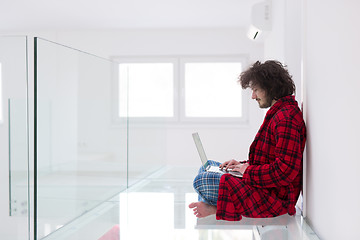 Image showing young freelancer in bathrobe working from home